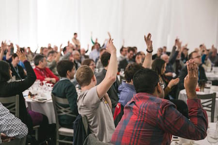 crowd-raising-hands-participating-conference